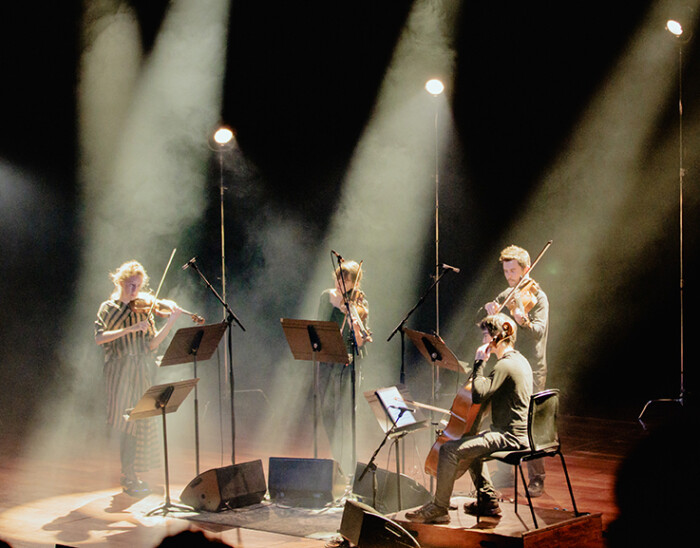 En stråkkvartett, som spelar på en scen, ur gruppen Manchester Collective